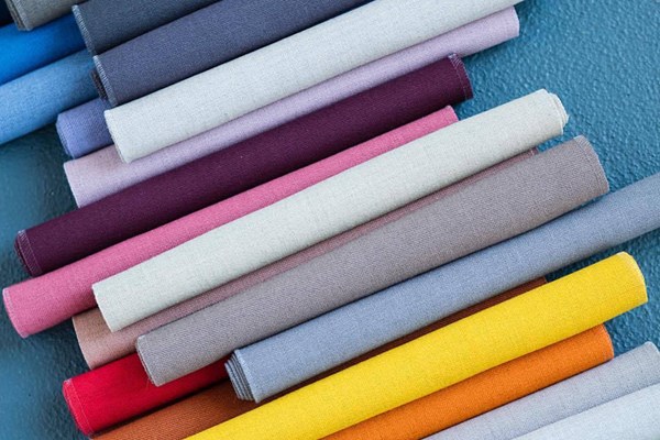 Textilrullar på rad i olika färger.