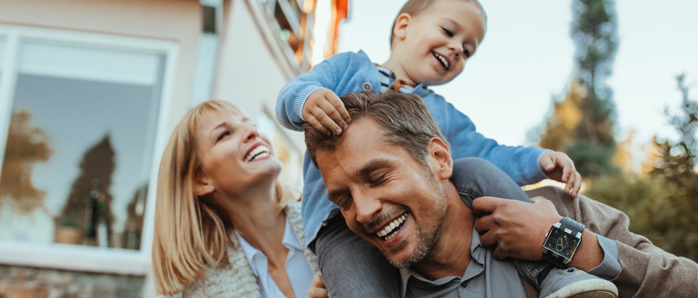 Familj med barnet på pappas axlar.